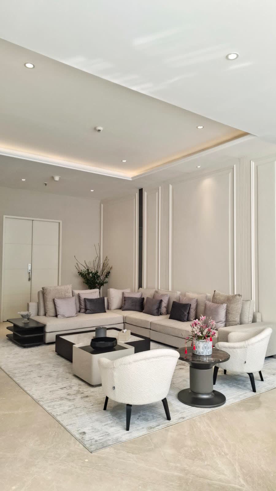 Ruang tamu dengan plafon bertingkat, LED cove, dan panel molding klasik